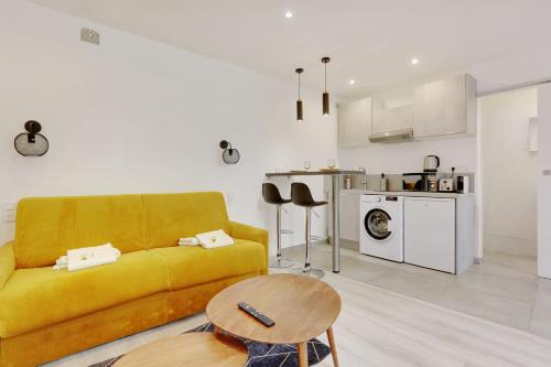 uma sala de estar com um sofá amarelo e uma mesa em Fully renovated studio Buttes-Chaumont em Paris