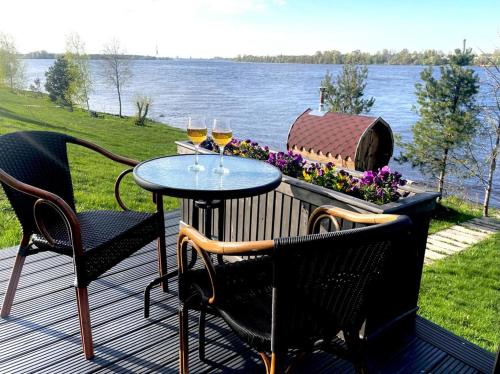 a patio with two tables and two glasses of wine at Doles skati in Salaspils