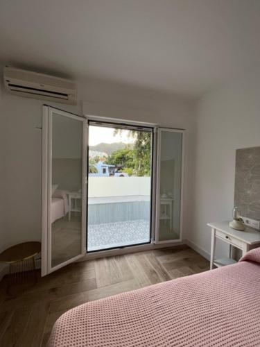 a bedroom with a bed and a large glass window at HELICES CENTRO SAN JOSE CABO DE GATA in San José