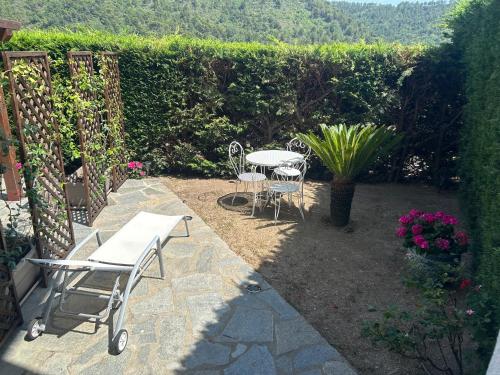 a patio with two tables and chairs and flowers at Apartment Mariuccia in Seborga in Seborga