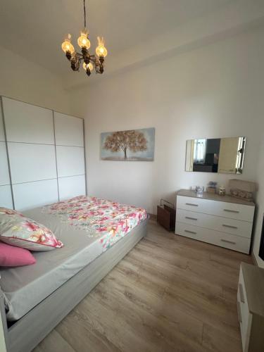 1 dormitorio con 1 cama, vestidor y lámpara de araña en Apartment Mariuccia in Seborga, en Seborga