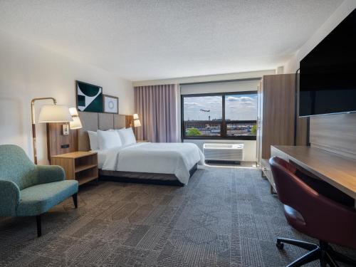 a hotel room with a bed and a large window at Staybridge Suites Chicago O'Hare - Rosemont by IHG in Rosemont