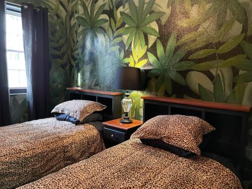 two beds in a bedroom with a wall mural at Belize Budget Suites in San Pedro