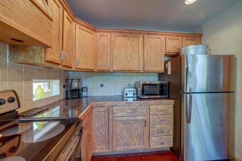 a kitchen with wooden cabinets and a stainless steel refrigerator at Boat Dock and Fire Pit Lakefront Paradise in Eucha! in Eucha