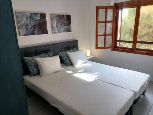 een slaapkamer met een groot bed met witte lakens en kussens bij Pine & sea house in Nikiti