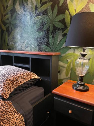 a bedroom with a bed and a table with a lamp at Belize Budget Suites in San Pedro