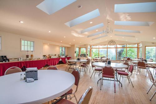 - une salle à manger avec des tables, des chaises et des fenêtres dans l'établissement White Rose Inns & Motel, à Wisconsin Dells
