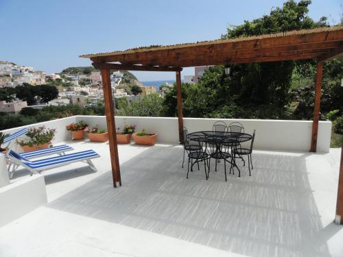 a patio with a table and chairs on a roof at Cavadozza by Caseaponza it in Ponza