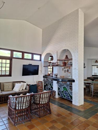 ein Wohnzimmer mit Couch und Kamin in der Unterkunft Casa Mar - Vila Gameleira in São Miguel dos Milagres