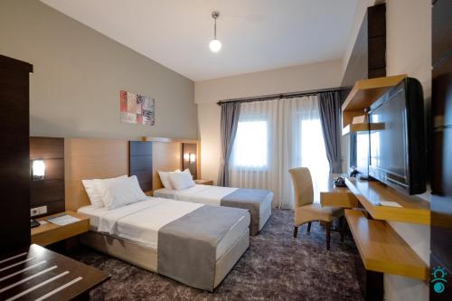 a hotel room with two beds and a flat screen tv at KTÜ Koru Otel in Trabzon