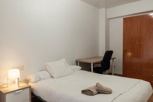 a bedroom with a bed with a desk and a chair at Funcional y renovado apartamento en Iturrama in Pamplona