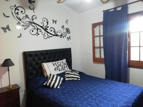 a bedroom with a bed with a blue comforter at La casa de Lily in Alta Gracia