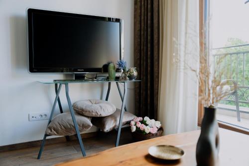 a television sitting on a table in a living room at Vrnjačka Promenada - Pešačka zona - Baby friendly in Vrnjačka Banja
