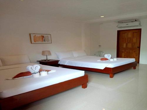 twee bedden in een hotelkamer met handdoeken erop bij Zosimo's Inn in Siquijor