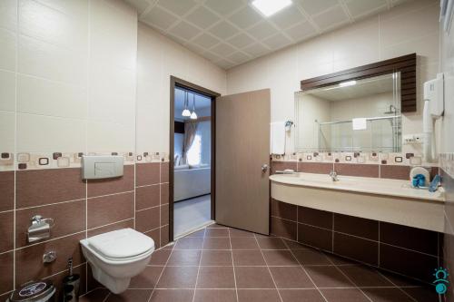 a bathroom with a toilet and a sink and a mirror at KTÜ Koru Otel in Trabzon