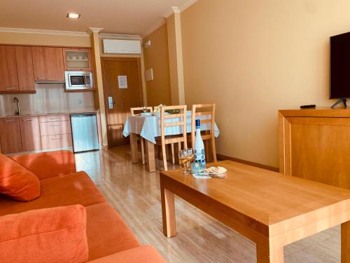 a living room with a table and a kitchen at Apartamentos Esperanza del Mar in Portonovo