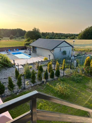 a view of a backyard with a pool and a house at Koniec Świata Stare Sady apartament in Mikołajki