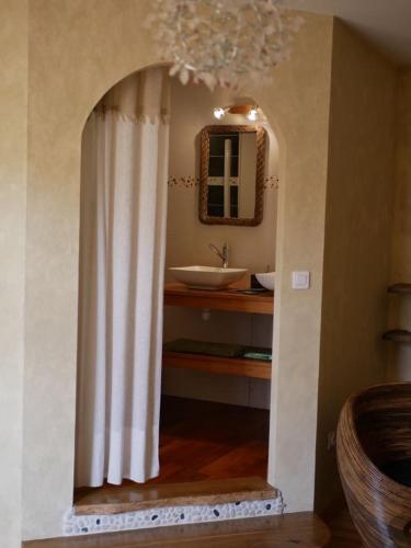 bagno con tenda da doccia bianca e lavandino di Les Jardins de Lumière a Brusque