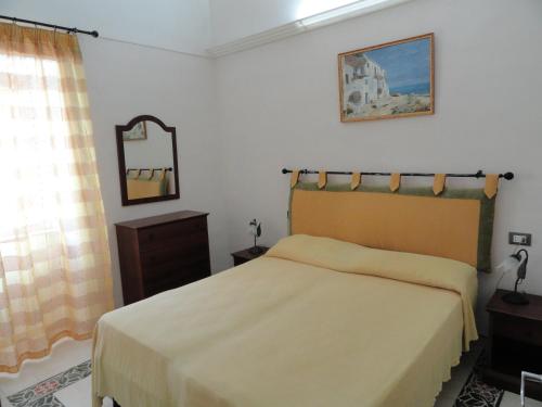 1 dormitorio con cama y espejo en la pared en Cavadozza, en Ponza