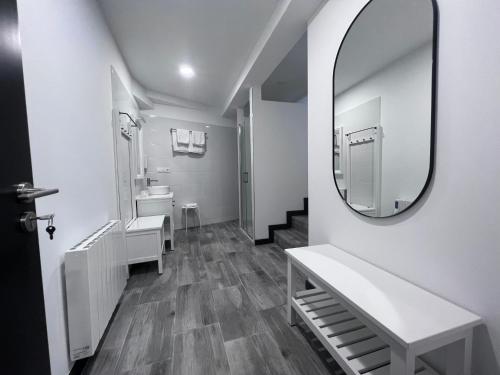uma casa de banho branca com um espelho e um lavatório em PENSION CASA JULIO ** em Culleredo