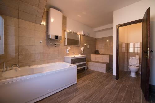 uma casa de banho com uma banheira, um lavatório e um WC. em Gardoš rooms em Zemun