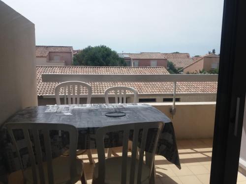 une table et des chaises sur un balcon avec vue dans l'établissement STUDIO LES PIEDS DANS L'EAU, à Canet