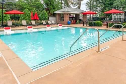 a swimming pool at a hotel with chairs and umbrellas at Urban Nest ATL in Atlanta
