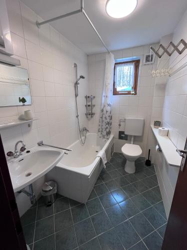 a bathroom with a tub and a sink and a toilet at Kaprun Mountain Studio with Summer CARD- Central Location in Kaprun