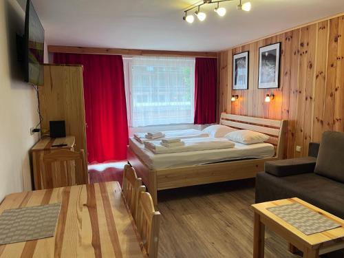 a small bedroom with a bed and a couch at Kaprun Mountain Studio with Summer CARD- Central Location in Kaprun