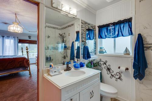 a bathroom with a sink and a toilet and a mirror at Tacoma Home on Steilacoom Lake with Dock! in Tacoma