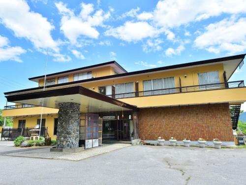 a large yellow building with a parking lot at Arya Hotel Alpin Route - Vacation STAY 81598v in Omachi