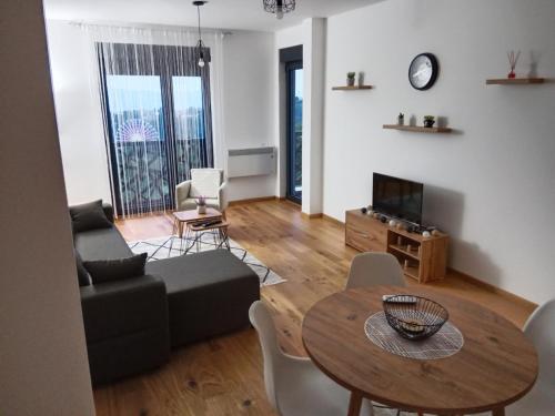 una sala de estar con una mesa y un sofá en Panorama 17, en Vrnjačka Banja