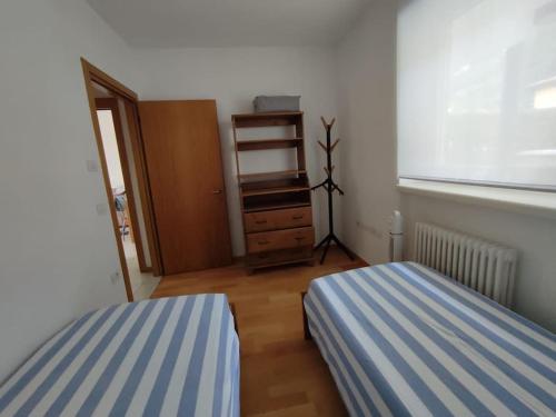 a bedroom with two beds and a dresser and a window at L&G APARTAMENT in Nago-Torbole