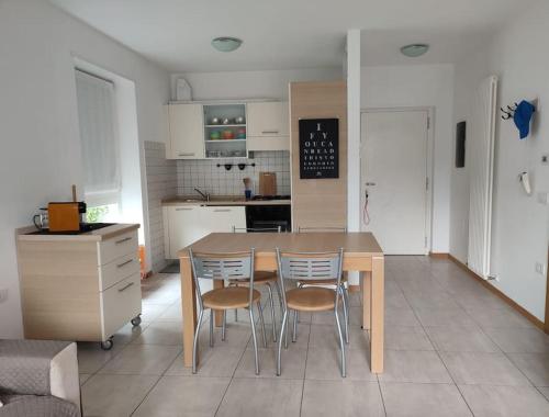 a kitchen with a table and chairs in a room at L&G APARTAMENT in Nago-Torbole