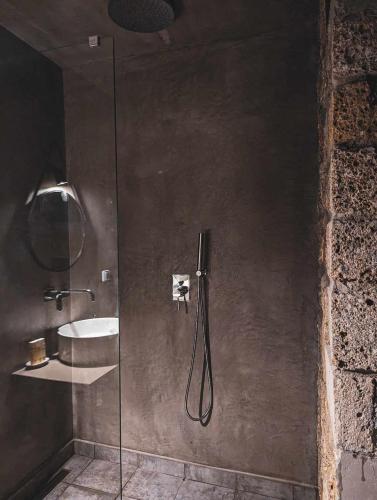 a shower with a glass door next to a sink at Three Dots Boutique Suites in Soúlion