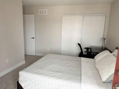a bedroom with a bed and a desk and a door at Private bedroom in Stittsville