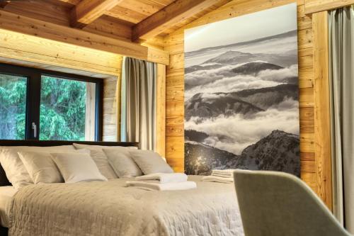 a bedroom with a bed with a picture of mountains at KRÁĽOVOHOĽSKÁ CHATA in Šumiac