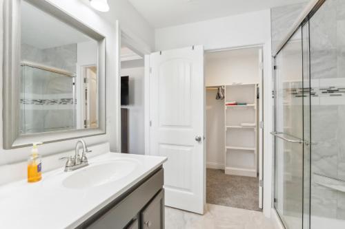 a white bathroom with a sink and a shower at Charming St Robert Home Near Downtown Waynesville! in Waynesville
