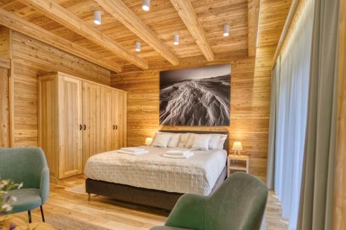 a bedroom with a bed and two chairs at KRÁĽOVOHOĽSKÁ CHATA in Šumiac