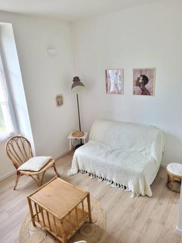 une chambre blanche avec un lit et une chaise dans l'établissement Cocoon Urbain Nantais, à Nantes