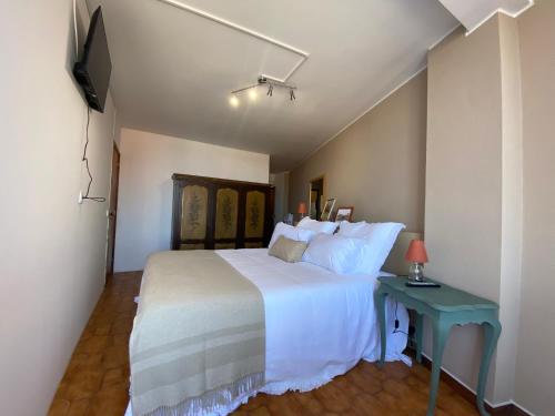 a bedroom with a white bed and a blue table at Jardim do Morro Places in Vila Nova de Gaia