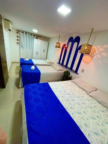 two beds in a room with surfboards on the wall at Residencial Temporada Aracaju in Aracaju