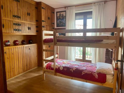 1 dormitorio con 2 literas y ventana en Rustic House Aosta, en Aosta
