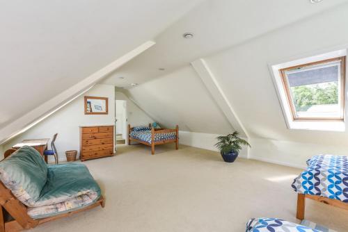 Taylors Copse Cottage by Inspire Stays في بيترزفيلد: غرفة علوية بجدران بيضاء ونافذة