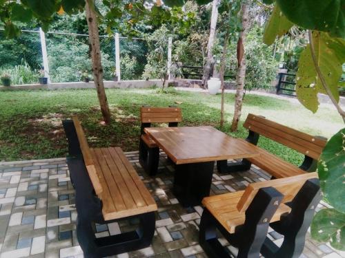 a picnic table and two benches sitting on a patio at White House Family Stay in Maspota