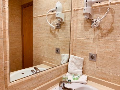 a bathroom with a sink and a mirror at Apartamentos Esperanza del Mar in Portonovo