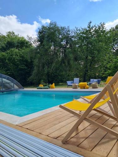 une piscine avec une chaise et une piscine dans l'établissement Domaine de Beaucamp, à Châtelraould-Saint-Louvent