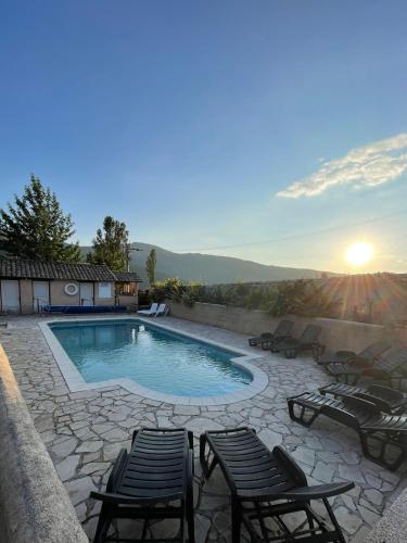 - une piscine avec des chaises et le coucher de soleil en arrière-plan dans l'établissement Camping Les Sirènes, à Castellane