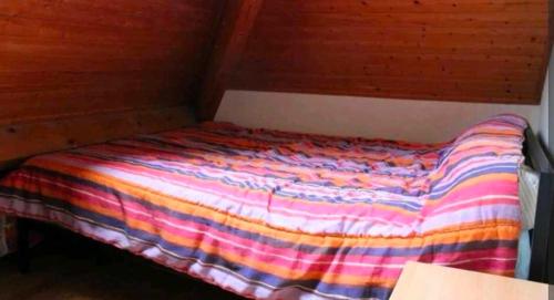 a bed with a colorful blanket on top of it at APPARTEMENT ESQUIEZE SERE in Luz-Saint-Sauveur