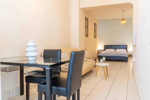 a living room with a dining table and a bedroom at Stay in calm in Kavála